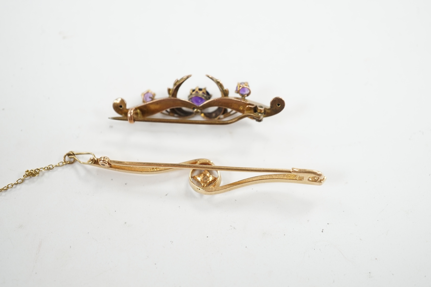 An Edwardian 15ct and diamond set crossover bar brooch, 57mm, gross weight 3.9 grams, together with a similar 9ct gold, amethyst and seed pearl set bar brooch, gross weight 2.3 grams. Condition - fair